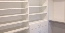 Walk-in closet with drawers, shoe tower and upper storage